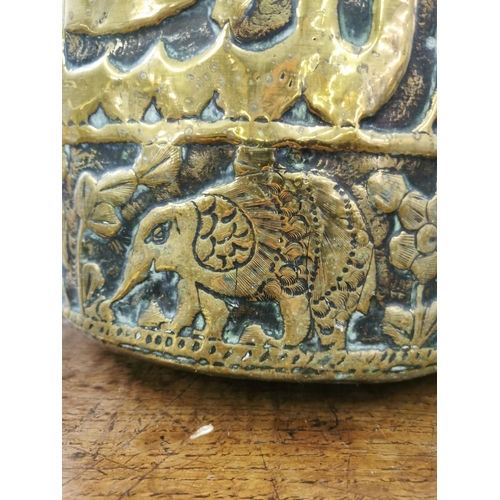 478 - A Middle Eastern embossed brass coal bucket with elephant and lion design - approx. 28cm high x 32cm... 