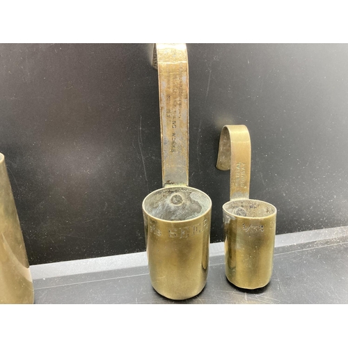 238 - A set of four vintage brass graduating measuring cups, two stamped 'The Oriental Metal Dressing Work... 