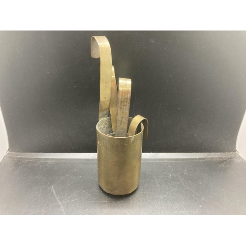 238 - A set of four vintage brass graduating measuring cups, two stamped 'The Oriental Metal Dressing Work... 