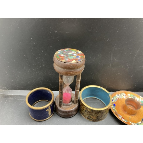 244 - Five items, one mahogany egg timer with enamel top, two enamel napkin rings, one cloisonné napkin ri... 