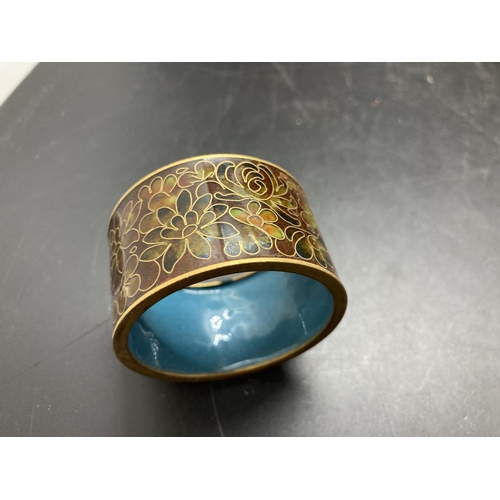 244 - Five items, one mahogany egg timer with enamel top, two enamel napkin rings, one cloisonné napkin ri... 