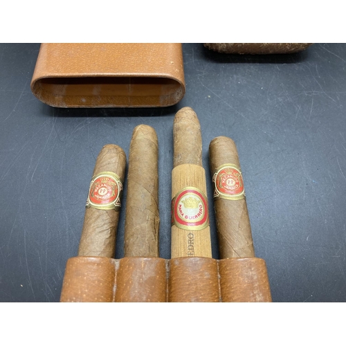 257 - Two vintage brown leather cigar cases, one containing four various cigars to include two Macanudo Ja... 