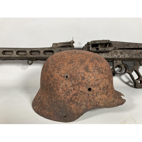 85 - A WWII German MG42 machine gun relic and helmet, found together on the Eastern Front in the area of ... 