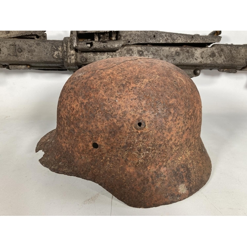 85 - A WWII German MG42 machine gun relic and helmet, found together on the Eastern Front in the area of ... 