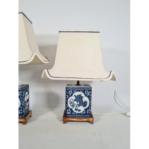 180 - A pair of oriental style blue and white ceramic bedside lamps with white and blue shades - approx. 5... 