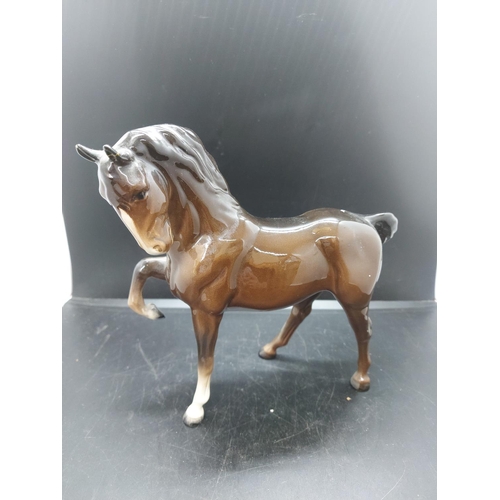 152 - Three figurines to include a Beswick prancing brown horse, Beswick pony and one other