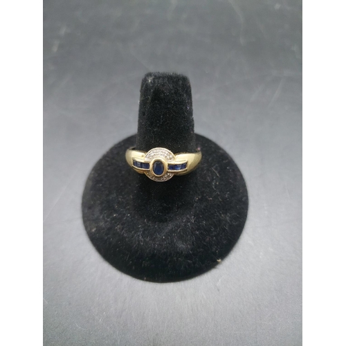 96 - A hallmarked 14ct gold sapphire and diamond ring with one central sapphire, six further sapphires an... 