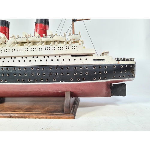 159 - A scratch built model of The RMS Queen Elizabeth ocean liner originally by Cunard with a solid wood ... 