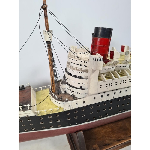 159 - A scratch built model of The RMS Queen Elizabeth ocean liner originally by Cunard with a solid wood ... 