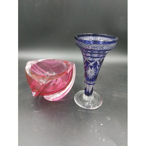 97 - Two items, one royal blue crystal glass 15cm bud vase and one cranberry crystal glass twisted ashtra... 