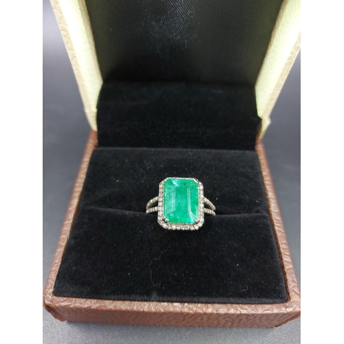 105 - A 925 silver and 6.65ct emerald ring with outer rose cut 0.60ct diamonds