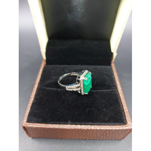 105 - A 925 silver and 6.65ct emerald ring with outer rose cut 0.60ct diamonds