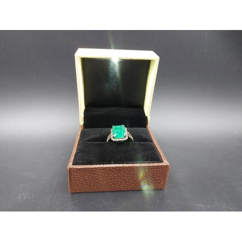 105 - A 925 silver and 6.65ct emerald ring with outer rose cut 0.60ct diamonds