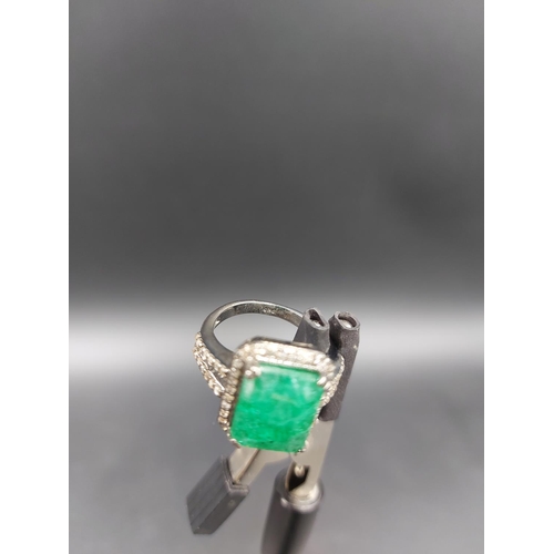 105 - A 925 silver and 6.65ct emerald ring with outer rose cut 0.60ct diamonds