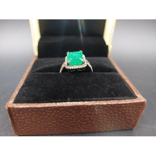 105 - A 925 silver and 6.65ct emerald ring with outer rose cut 0.60ct diamonds