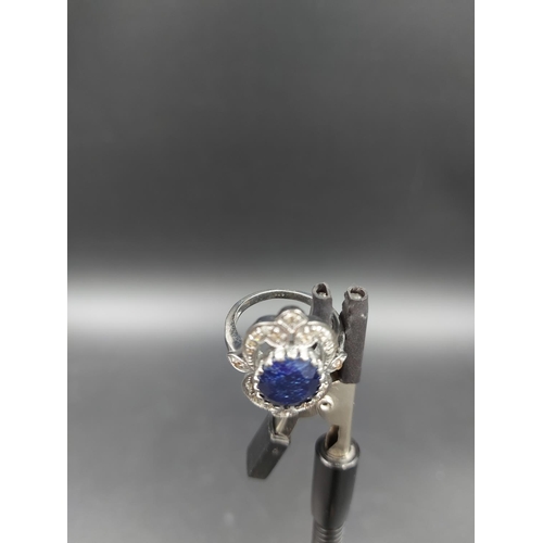 120 - A 925 silver and 7ct blue sapphire ring with outer rose cut 0.60ct diamonds