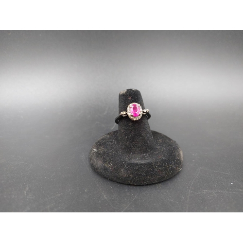 121 - A 925 silver and 1.30ct ruby ring with outer 0.30ct diamonds