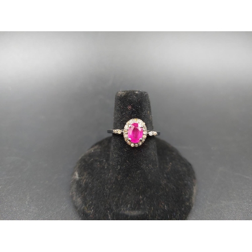 121 - A 925 silver and 1.30ct ruby ring with outer 0.30ct diamonds