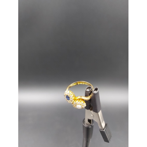 137 - A hallmarked 18ct gold ring with large inset sapphire, inset pearl and 15 surrounding diamonds, size... 