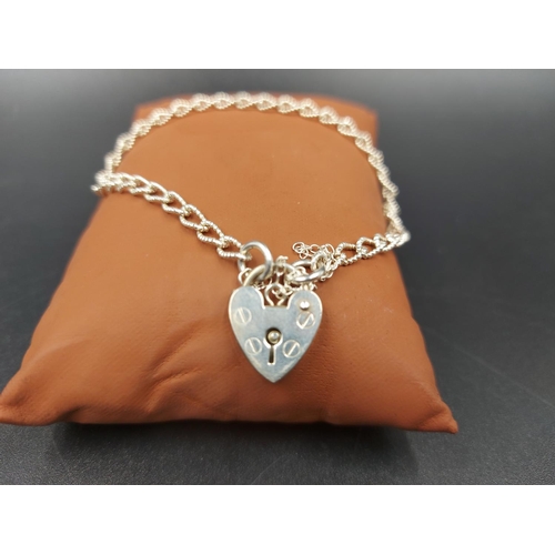 153 - A white metal ladies bracelet with stamped sterling silver heart shaped padlock clasp