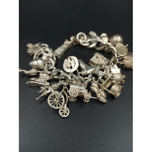 168 - A hallmarked London silver charm bracelet containing various silver charms - approx. gross weight 10... 