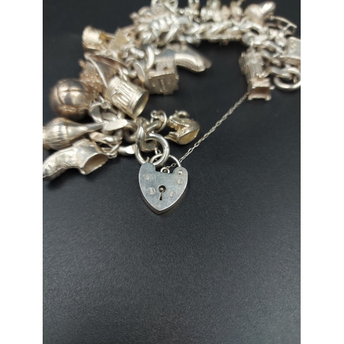 168 - A hallmarked London silver charm bracelet containing various silver charms - approx. gross weight 10... 