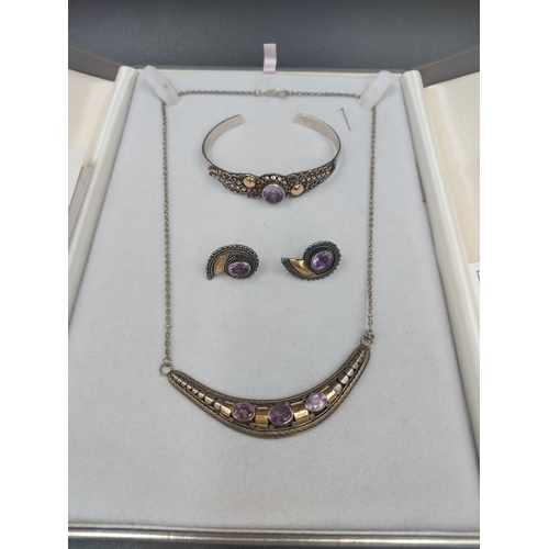 185 - A cased 925 silver and amethyst three piece jewellery set comprising necklace, bracelet and pair of ... 