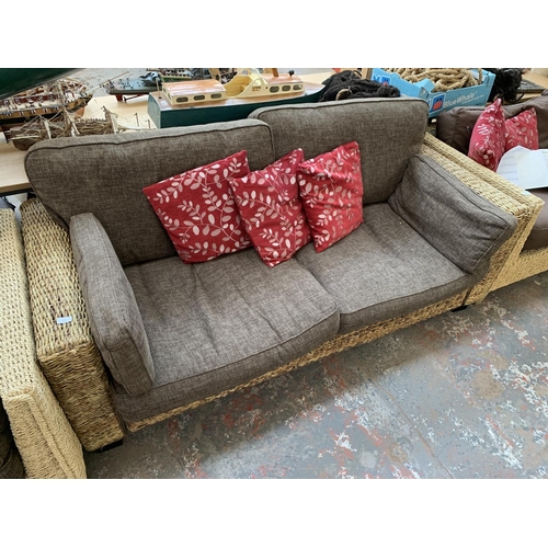 555 - A modern wicker and brown upholstered two seater sofa