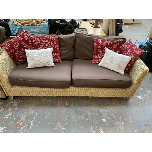 556 - A modern wicker and brown upholstered two seater sofa