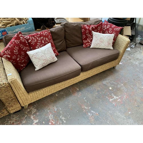 556 - A modern wicker and brown upholstered two seater sofa