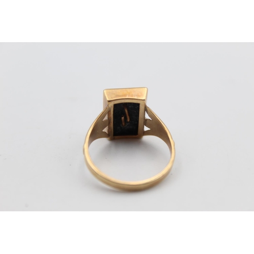 12 - A 9ct gold onyx initial ‘D’ ring, size V ½ - approx. gross weight 4.2 grams