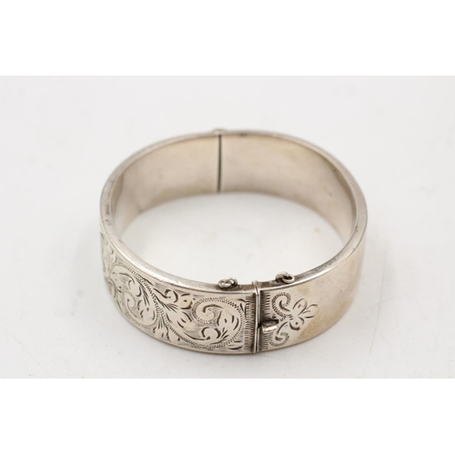 163 - A hallmarked Birmingham silver bangle with engraved scrolling design, dated 1964 - approx. gross wei... 