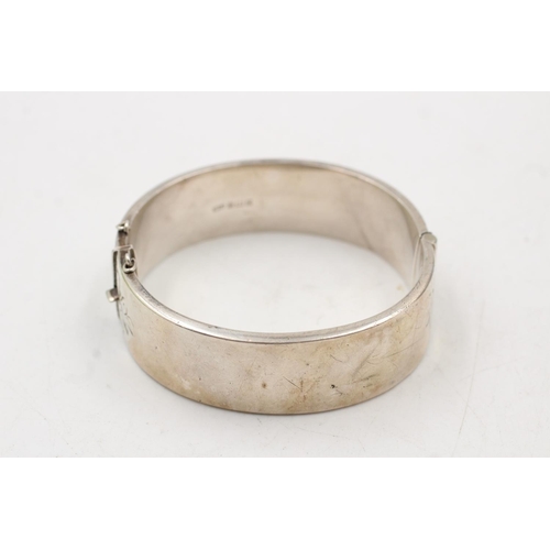 163 - A hallmarked Birmingham silver bangle with engraved scrolling design, dated 1964 - approx. gross wei... 