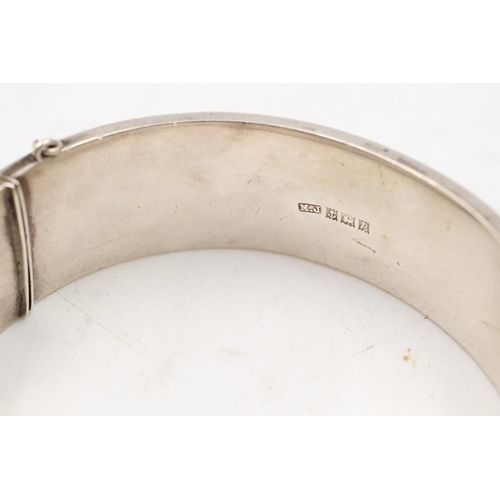 163 - A hallmarked Birmingham silver bangle with engraved scrolling design, dated 1964 - approx. gross wei... 