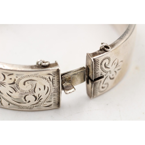 163 - A hallmarked Birmingham silver bangle with engraved scrolling design, dated 1964 - approx. gross wei... 