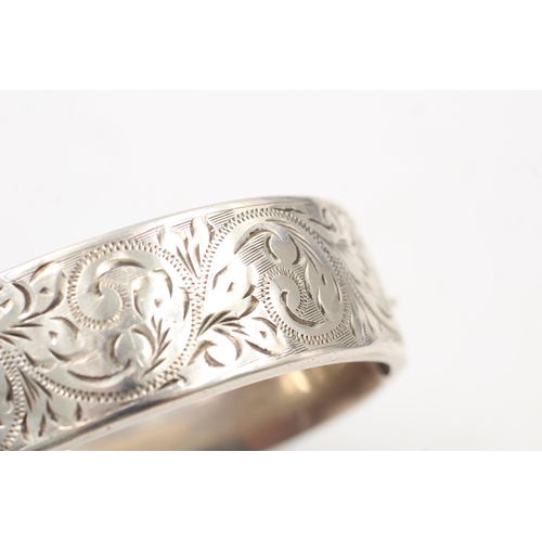 163 - A hallmarked Birmingham silver bangle with engraved scrolling design, dated 1964 - approx. gross wei... 