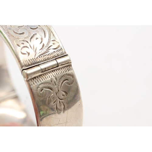 163 - A hallmarked Birmingham silver bangle with engraved scrolling design, dated 1964 - approx. gross wei... 