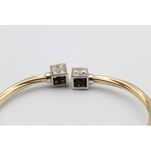 31 - A 9ct gold torque bangle with cuboid ends - approx. gross weight 9.2 grams