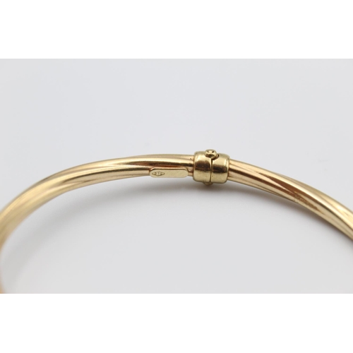 31 - A 9ct gold torque bangle with cuboid ends - approx. gross weight 9.2 grams