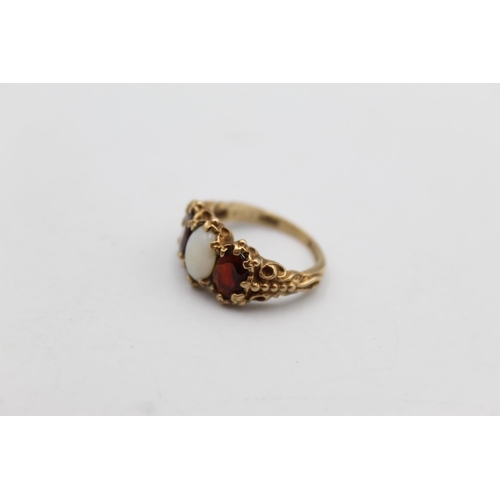 44 - A 9ct gold garnet and opal gypsy style ring, size J - approx. gross weight 4 grams