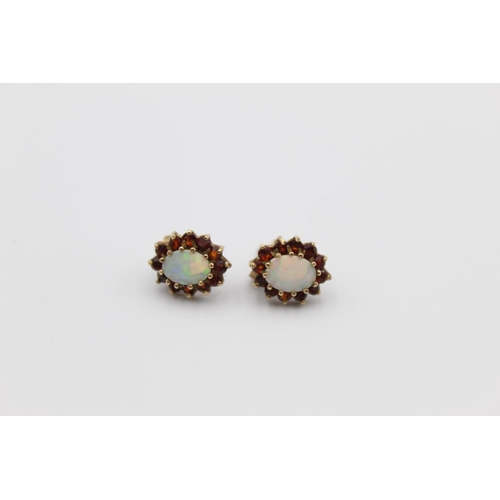 62 - A pair of 9ct gold opal and garnet halo stud earrings - approx. 1.7 grams