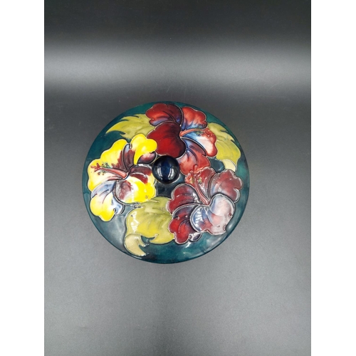 373 - A Moorcroft Hibiscus pattern circular lidded trinket box - approx. 14cm diameter x 9cm high with lid