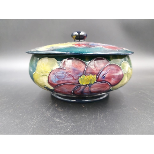 373 - A Moorcroft Hibiscus pattern circular lidded trinket box - approx. 14cm diameter x 9cm high with lid