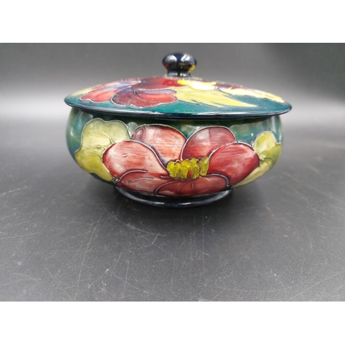 373 - A Moorcroft Hibiscus pattern circular lidded trinket box - approx. 14cm diameter x 9cm high with lid