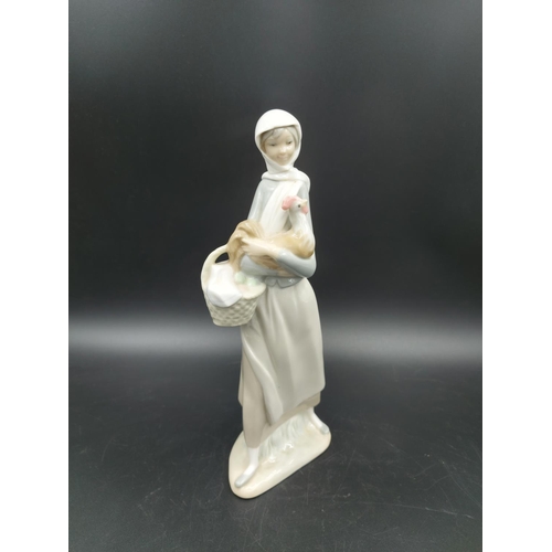 392 - Three figurines, one Lladro Angel With Flute model  no. 4540, one Lladro Lady With Basket and Chicke... 