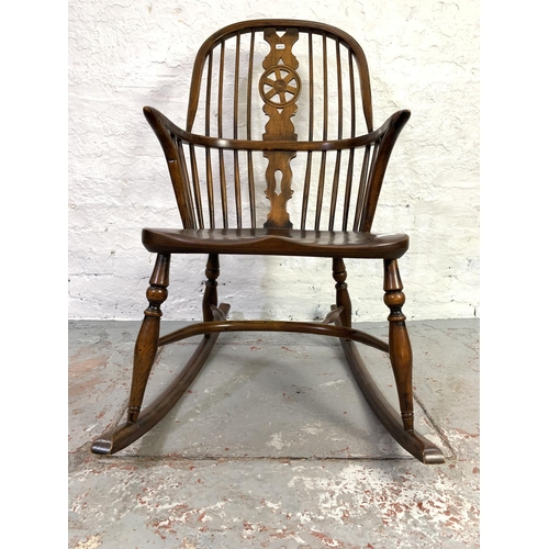 658 - A 19th century style elm wheel back Windsor rocking chair