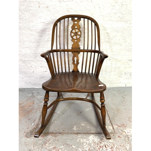 658 - A 19th century style elm wheel back Windsor rocking chair