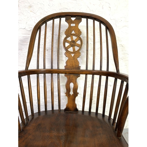 658 - A 19th century style elm wheel back Windsor rocking chair