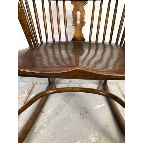 658 - A 19th century style elm wheel back Windsor rocking chair