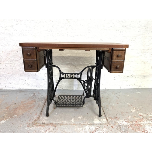 683 - A Singer treadle sewing machine cast iron base with teak table top